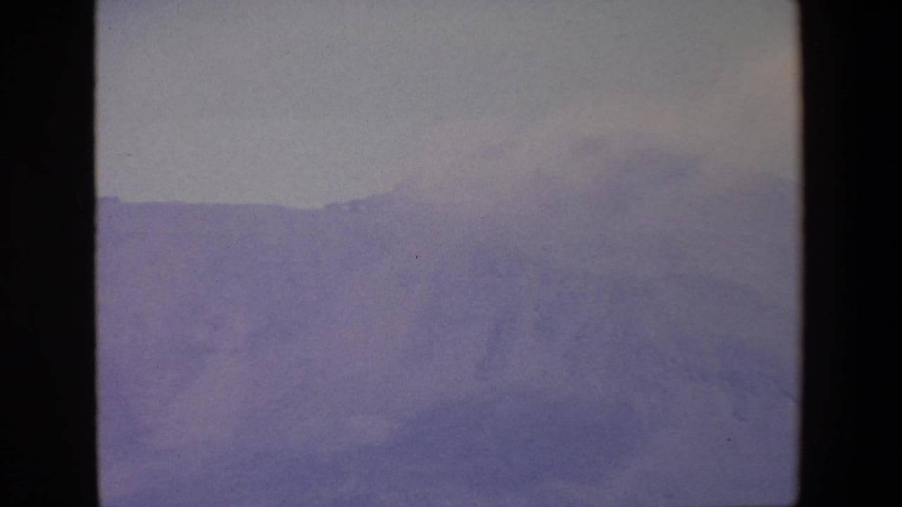 Hazy mountain range with a broad gray sky above.