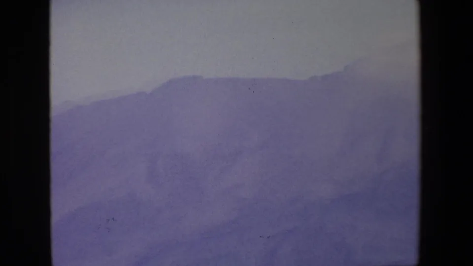 1967 Palermo-area 8mm frame showing a lower section of mountain ridge, softened by mist and muted film color.