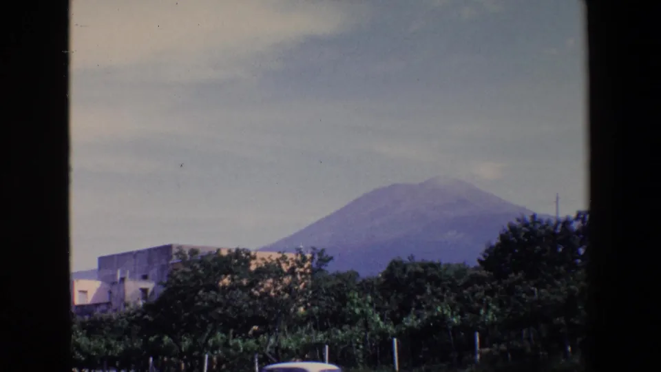 A second 8mm frame shows Mount Vesuvius in the distance, partly softened by haze, with trees and buildings in the foreground.