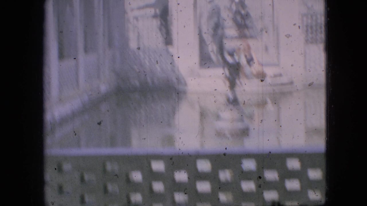 Faded 1968 Branson, Missouri home-movie frame showing a sunlit fountain area with pale masonry, decorative lattice, reflective water, and indistinct people near the basin.