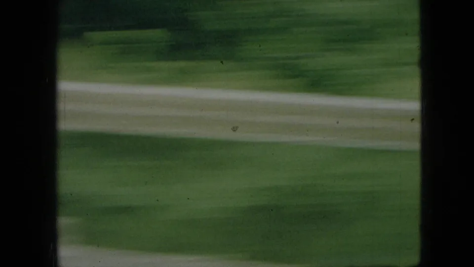 A fast-moving view of green lawn and a pale curving path closes the Branson, Missouri park clip with strong motion blur.
