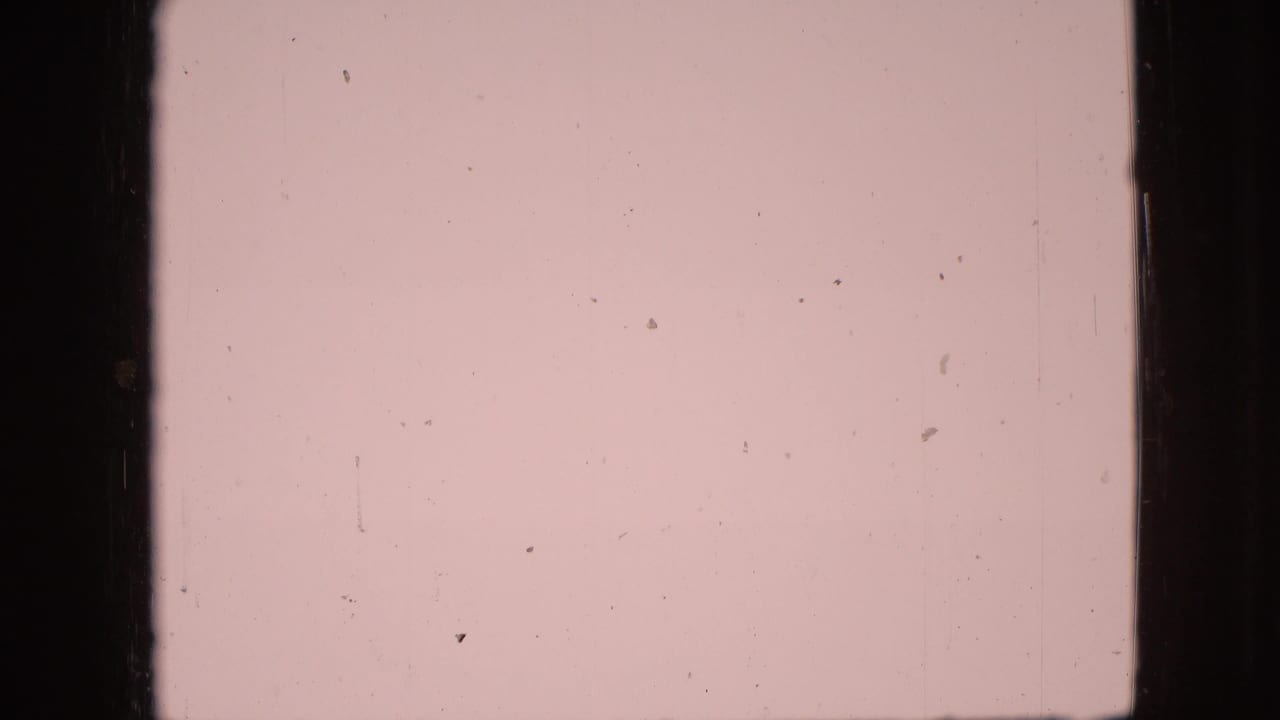 1968 8mm home-movie frame associated with Branson, Missouri, showing a pale sky and faint beach horizon behind heavy film gate edges and dust.
