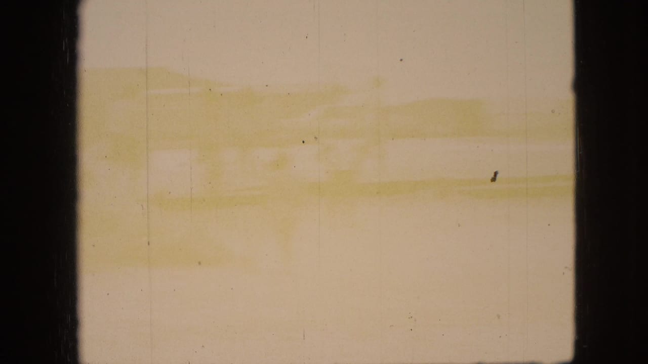 1968 Branson, Missouri home-movie frame showing pale water or shoreline tones through dark vertical borders, with visible grain and aging marks.