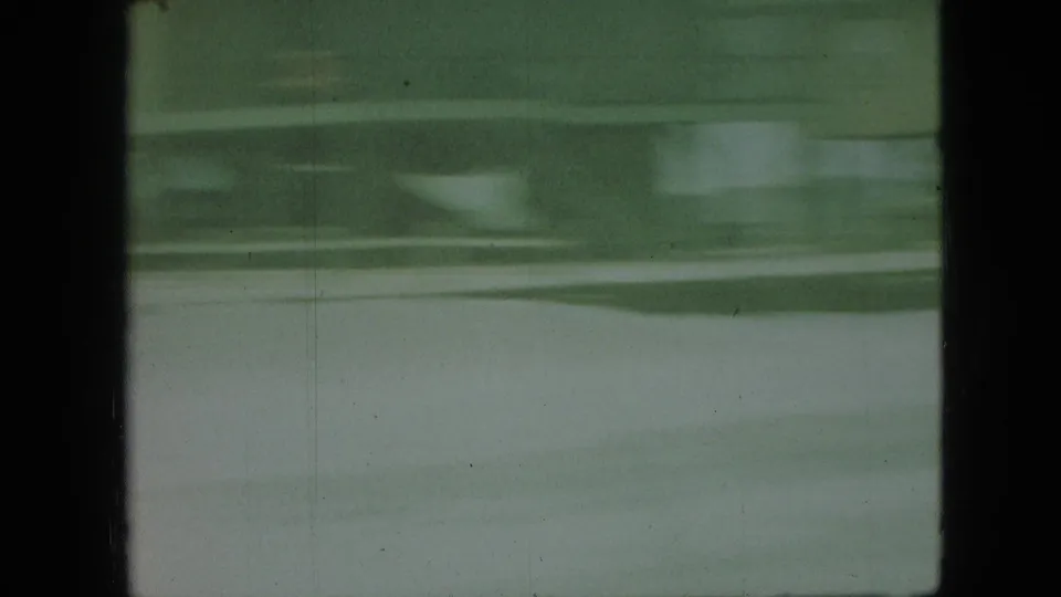 Green-tinted 8mm frame from the Branson vacation clip showing wavy water bands, dark borders, and soft handheld blur.
