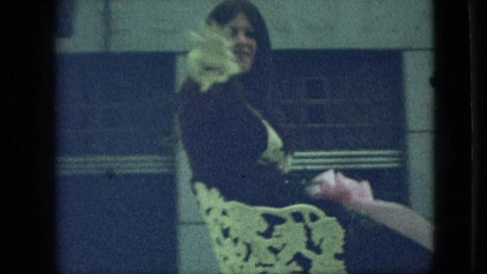 The parade participant appears seated on a decorated vehicle with white trim and flowers, filmed from a close spectator angle in the supplied 1968 Branson footage.