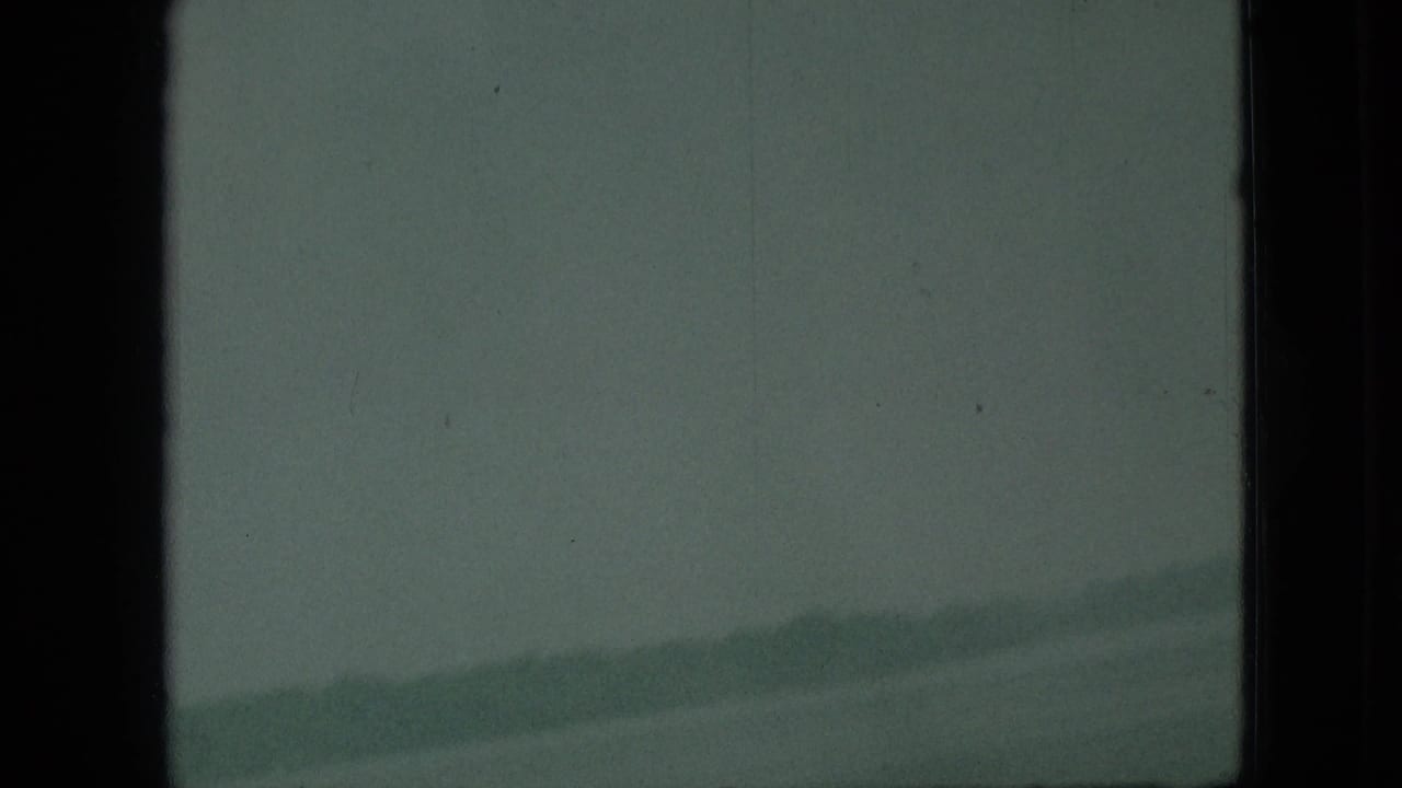 Hazy water or sky with a faint distant ridge crossing the right side.