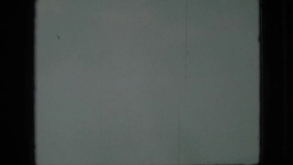 1968 Branson, Missouri 8mm frame showing an indistinct pale water or sky surface, dark gate-like edges, fine scratches, and uneven exposure.