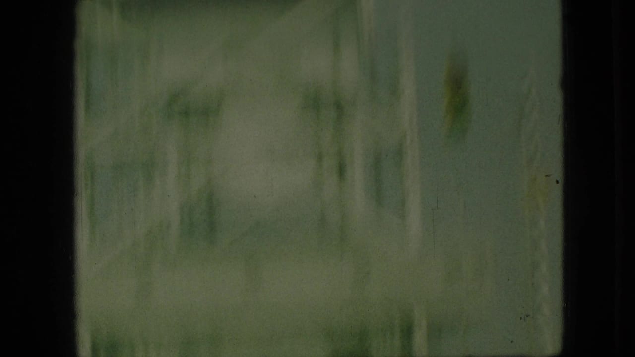 Soft 1968 8mm frame from Branson, Missouri showing a blurred steel bridge structure through a dark vehicle-window edge.