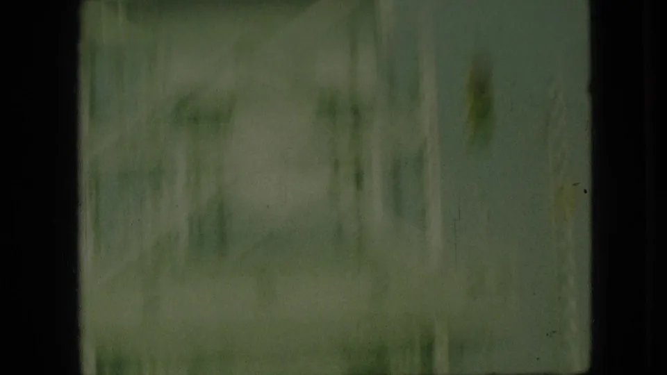 Soft 1968 8mm frame from Branson, Missouri showing a blurred steel bridge structure through a dark vehicle-window edge.