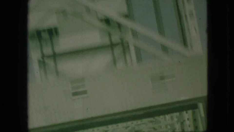 Angled 1968 8mm frame from Branson, Missouri showing the side of a steel bridge with railings and truss members passing close to the camera.