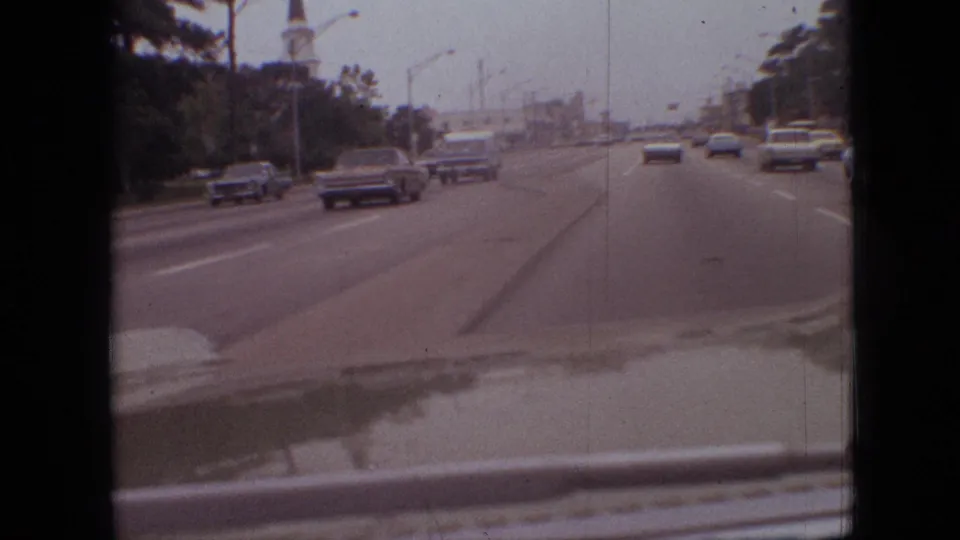 1968 Branson, Missouri driving footage showing several period cars on a multi-lane roadway with trees to the side and the filming vehicle's dashboard visible.