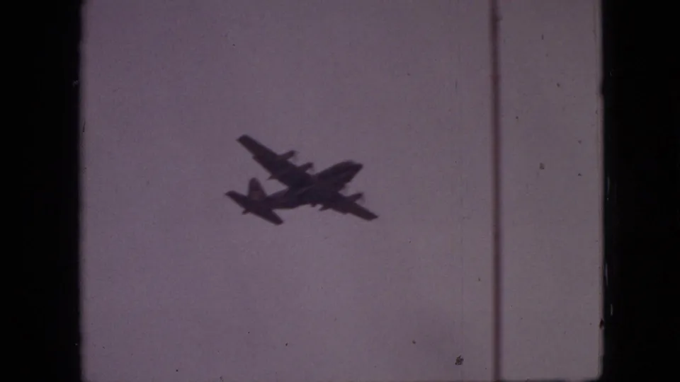 The aircraft silhouette appears larger and slightly lower in frame, with visible 8mm grain and scratches in the 1968 Branson, Missouri footage.