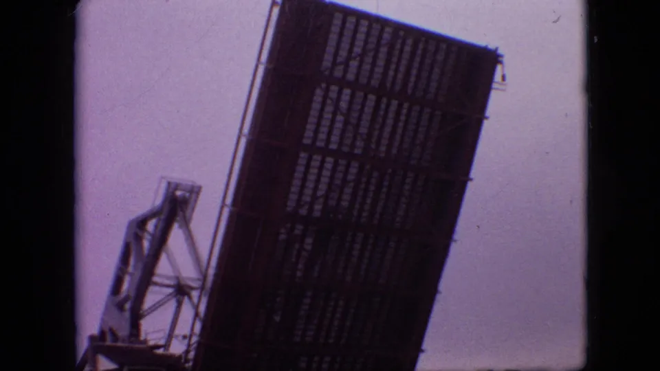 1968 Branson clip frame showing a large raised metal bridge or drawbridge structure against a pale, softly exposed sky.