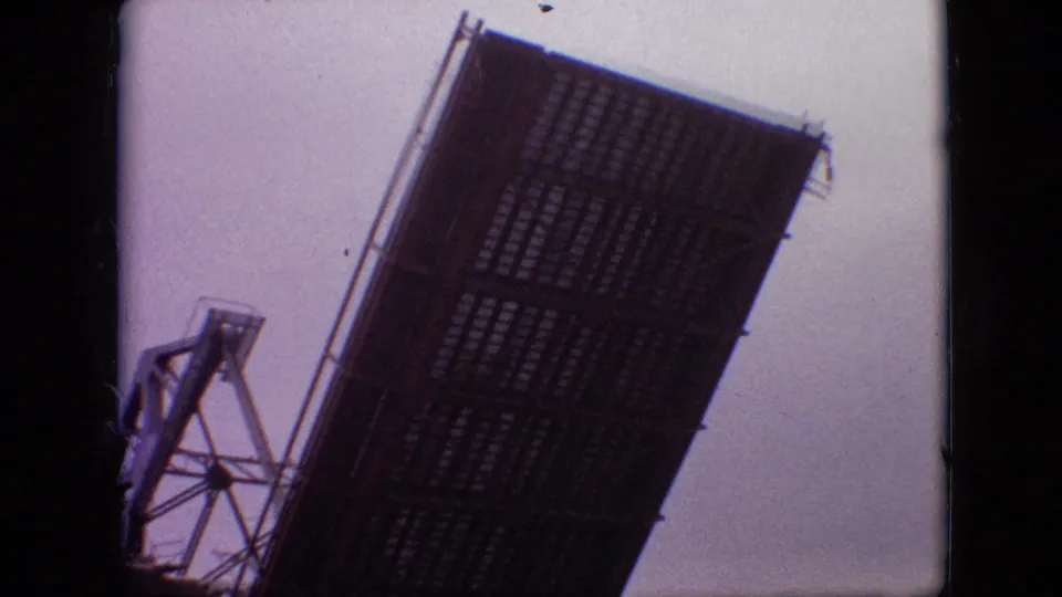 1968 Branson, Missouri 8mm frame centered on the raised bascule bridge leaf, with the steel tower partly visible at left and soft sky behind it.