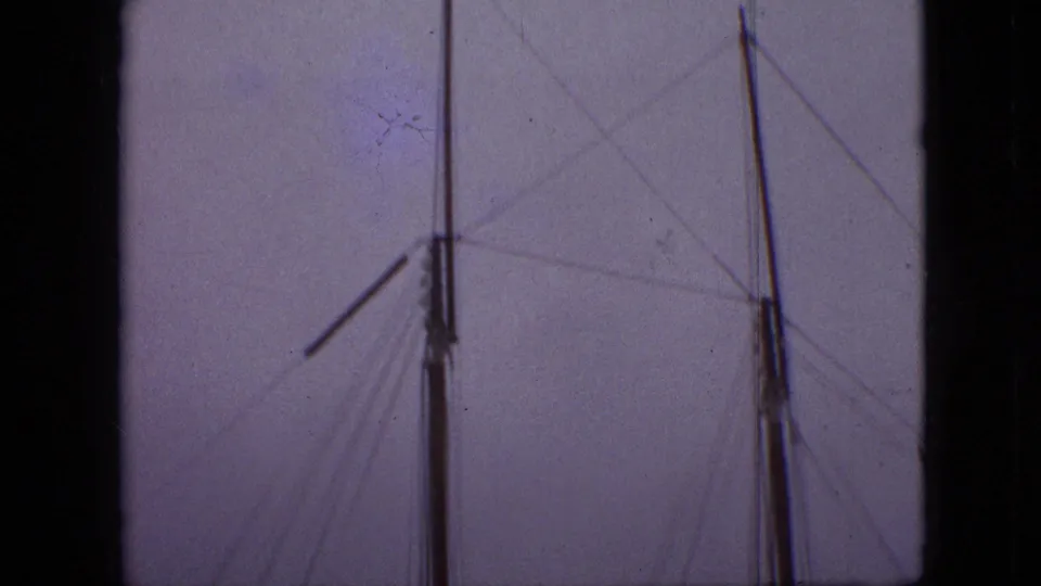 1968 Branson, Missouri home-movie frame showing mast tops and rigging lines partially obscured by dark vertical framing.