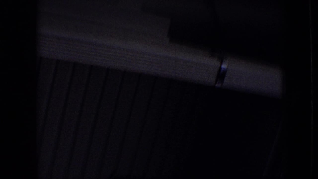 Very dark interior frame with a horizontal light-toned beam and shadowed vertical surfaces.