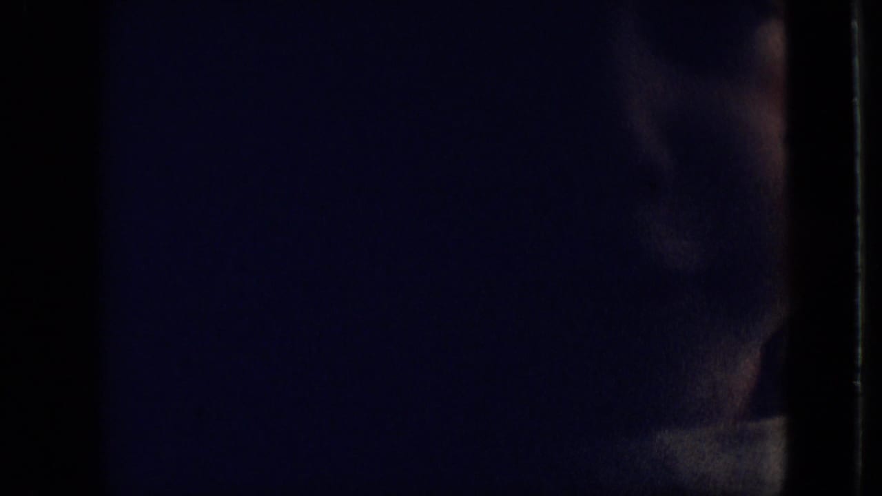 Dark close view of a child's head and shoulder near the right edge of the frame.