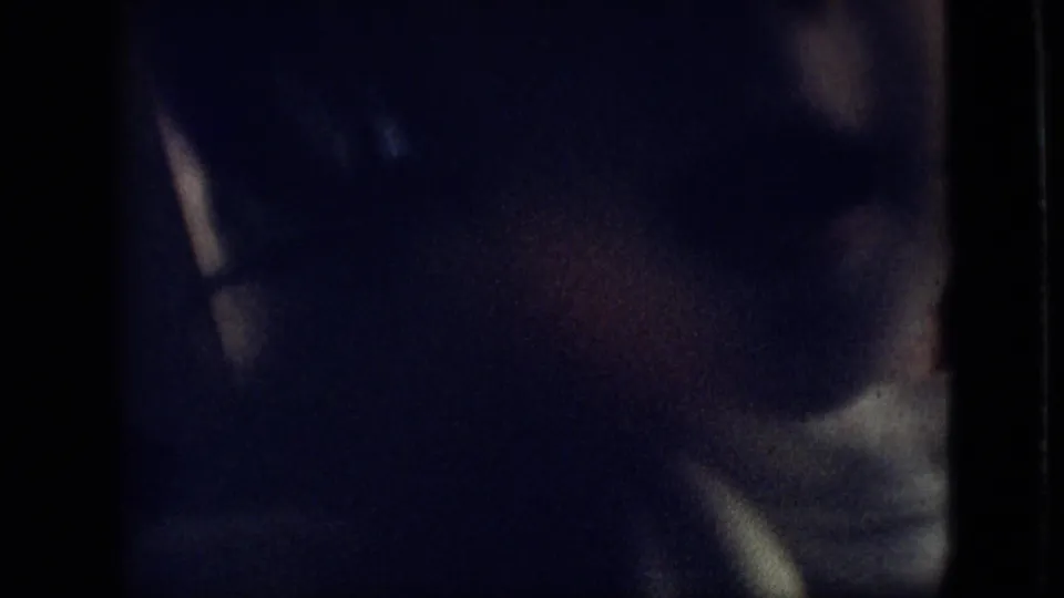 The toddler's shadowed face and raised hand are visible in a low-light 1968 Branson, Missouri home-movie frame, with strong grain and soft focus.