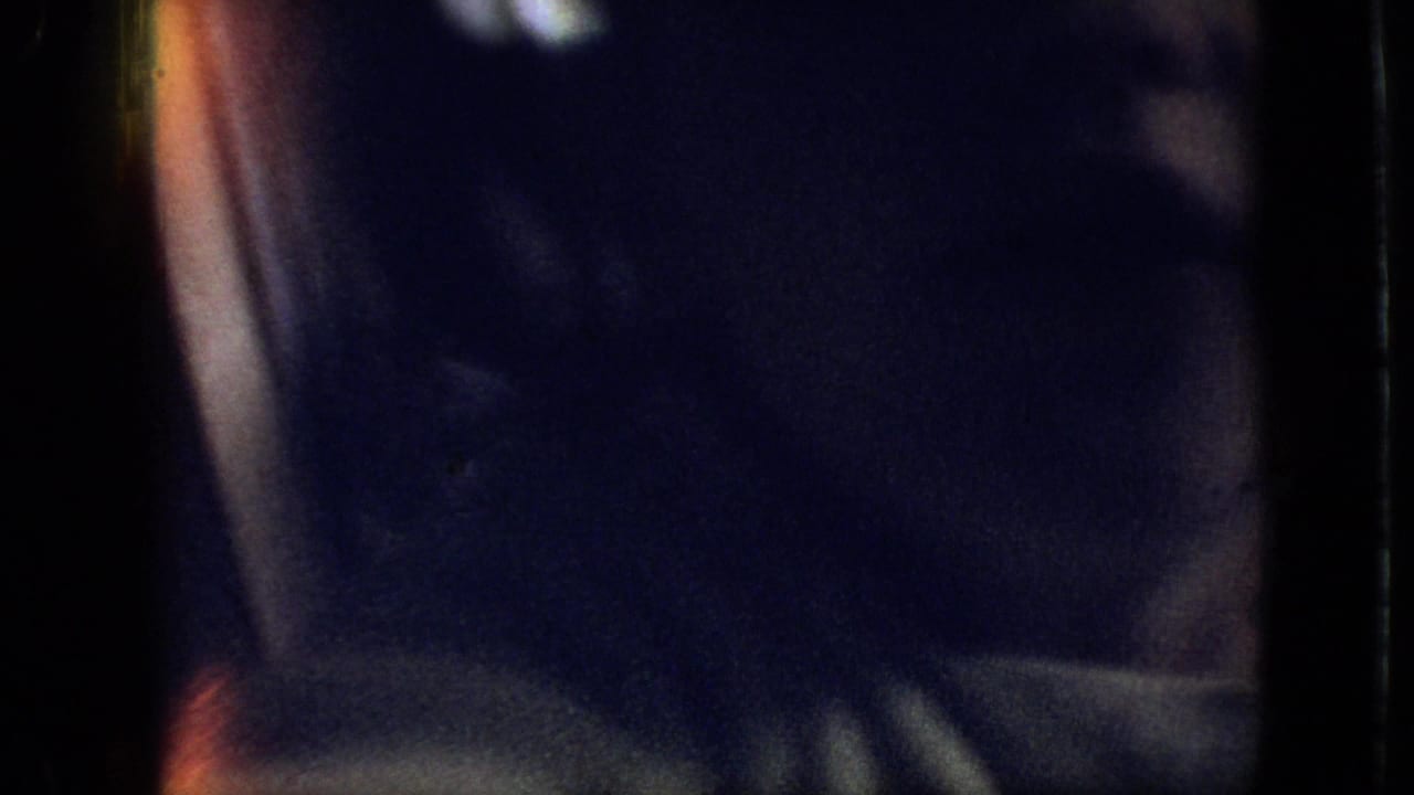 Dim close view of a person inside a vehicle with reflections and dark upholstery.