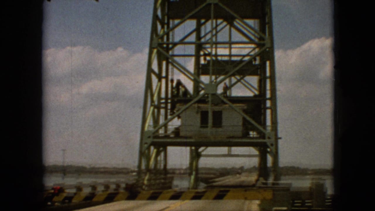 Raised steel bridge tower with a control cabin and striped roadway barrier.