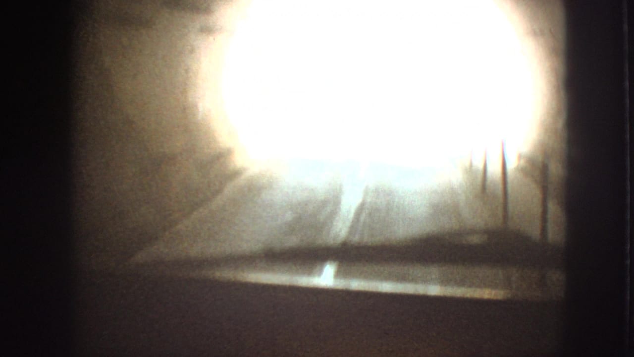 Bright overexposed tunnel exit seen from inside a car.