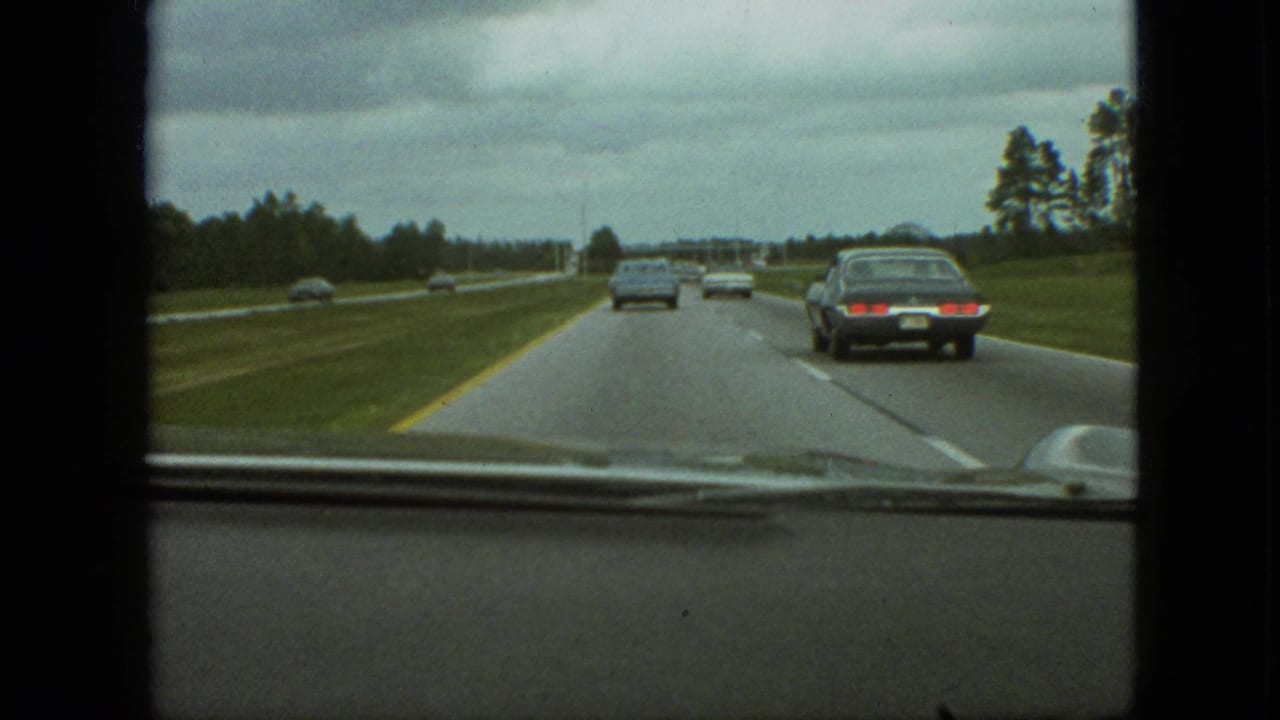 Forward view from a car on a multi-lane highway with several vehicles ahead.