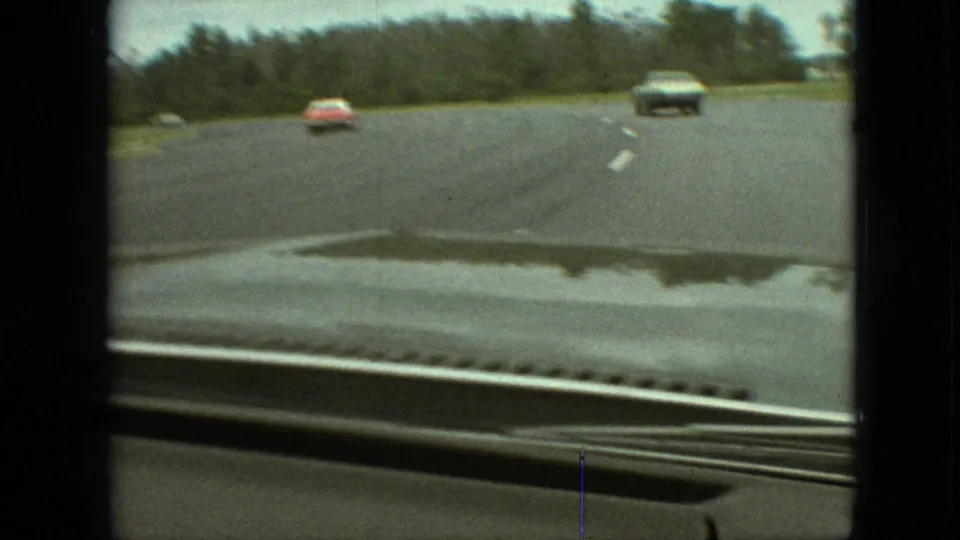 The final frame shows traffic ahead on a broad 1968 Branson roadway, framed by the filming car's windshield and soft 8mm exposure.