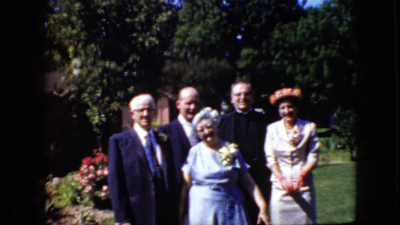 Adults continue posing outdoors in formal clothing, with the older woman in blue near the center and the woman in white at right.