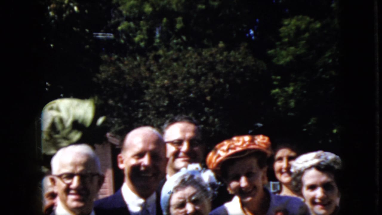Group of adults outdoors smiling at the camera with trees behind them.