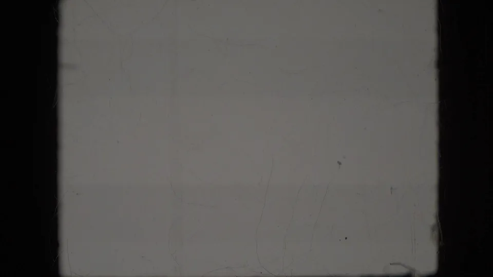 Faded 1969 8mm home-movie frame from the California reel, mostly overexposed with dark gate borders, dust, and faint surface marks but no clear subject visible.