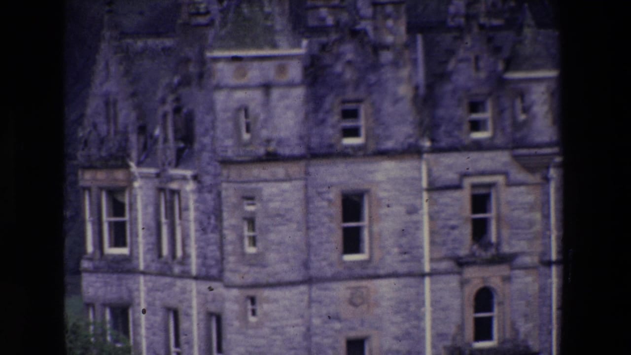 Soft 8mm view of a large stone building in Ireland, with windows and weathered masonry visible through dark frame edges.