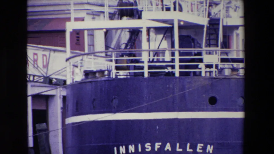 1969 Ireland 8mm frame showing the upper deck railings, ladders, portholes, and partial INNISFALLEN lettering on a docked ship.