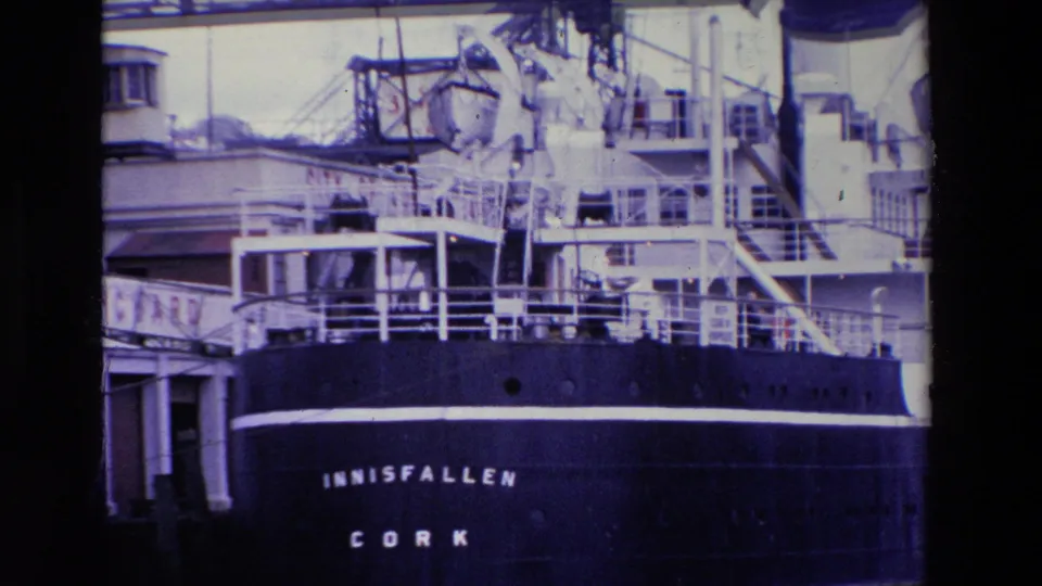 Stern view of the INNISFALLEN at an Irish port in 1969, with the ship name, CORK lettering, white railings, and dockside structure visible.
