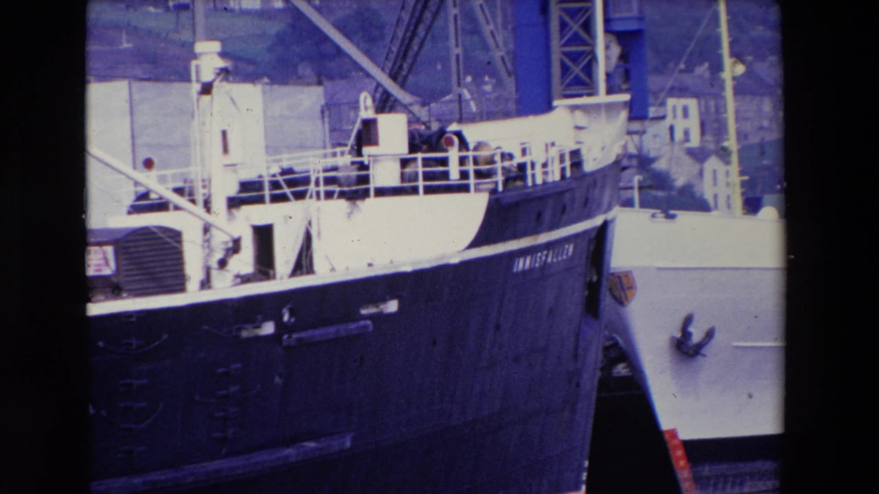 Bow and deck of the INNISFALLEN beside a white vessel at the dock.