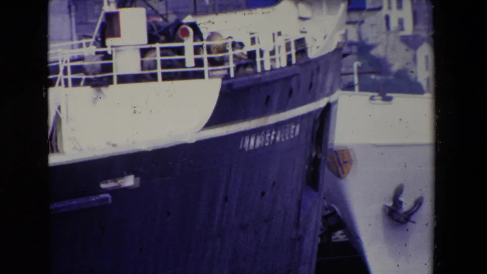1969 Ireland home-movie frame with the INNISFALLEN name visible on a dark hull next to a white vessel and port structures.
