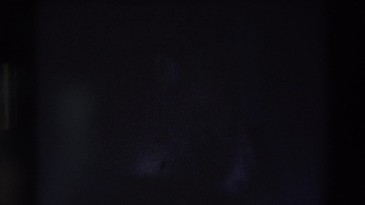 Dark underexposed frame with faint shadowed forms.