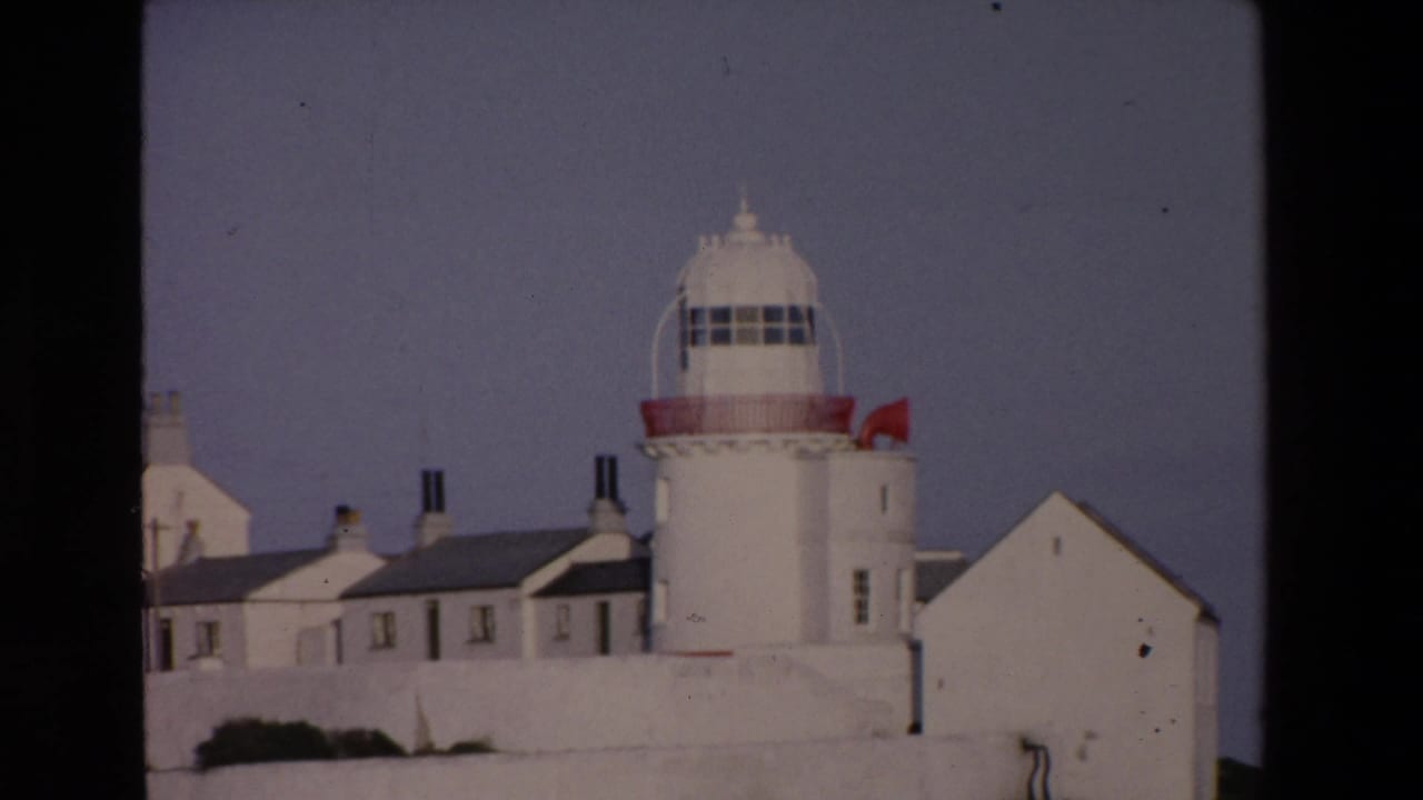White lighthouse and adjacent buildings seen from a similar angle.