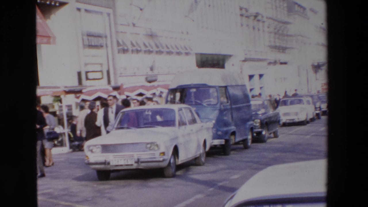 A French street scene from the supplied 1969 metadata shows a white sedan, blue van, pedestrians, awnings, and storefronts along a busy curb.