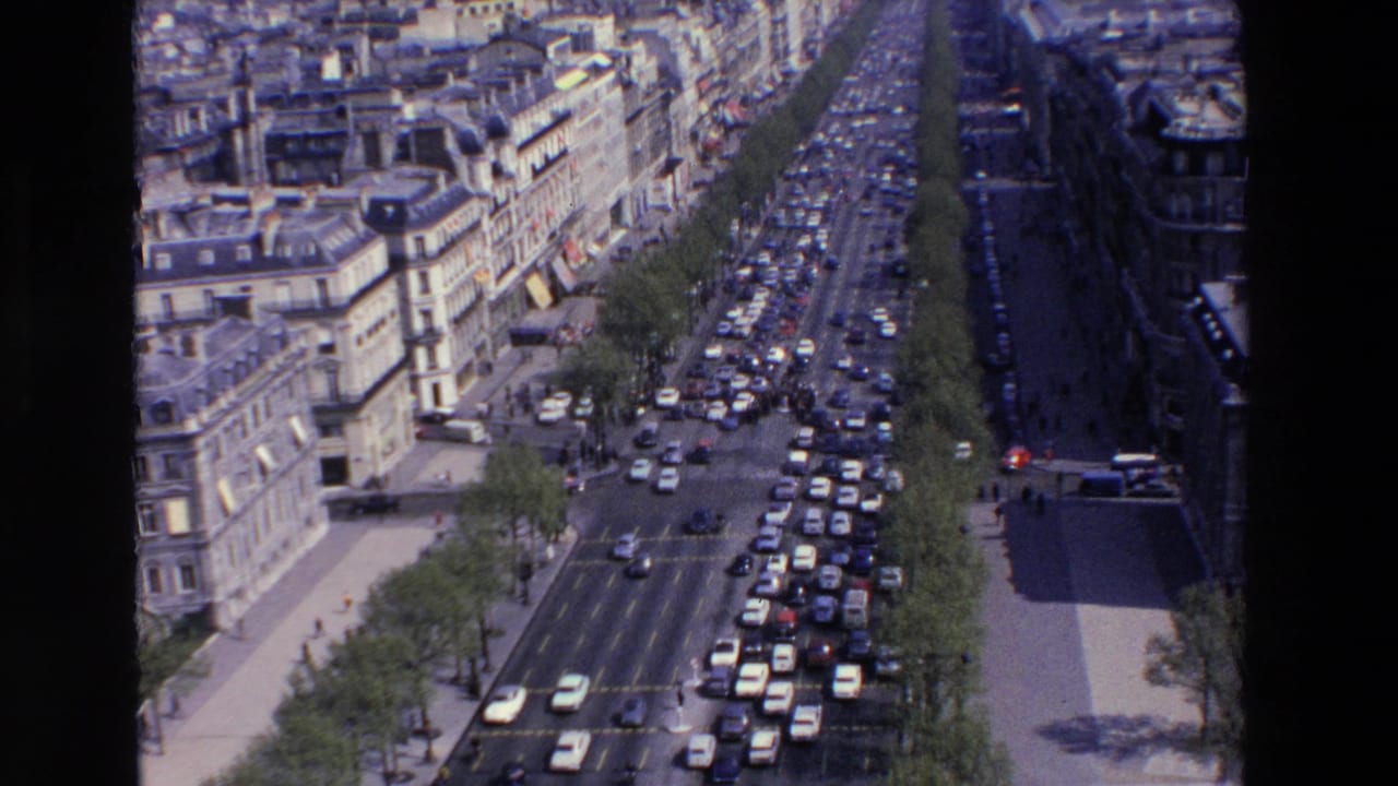 Traffic congestion continues along a wide boulevard viewed from above.