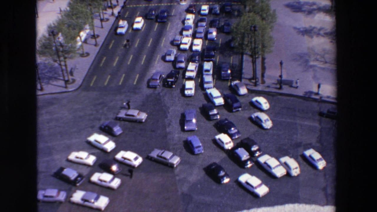 Traffic backs up at a multi-lane roundabout with cars entering and exiting from several directions.
