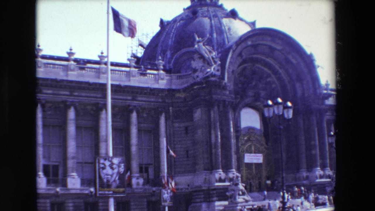 1969 Paris 8mm frame showing a French flag at half-mast before a grand domed Beaux-Arts building with columns, scaffolding, a streetlamp, a poster, and small pedestrians.