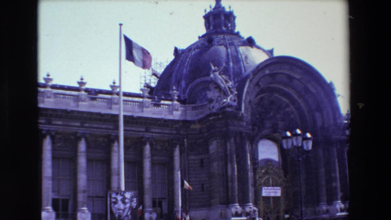 1969 Paris frame of a historic domed facade with the French flag lowered on a tall pole, rooftop ornament, scaffolding, and a poster showing a woman's face near the lower left.