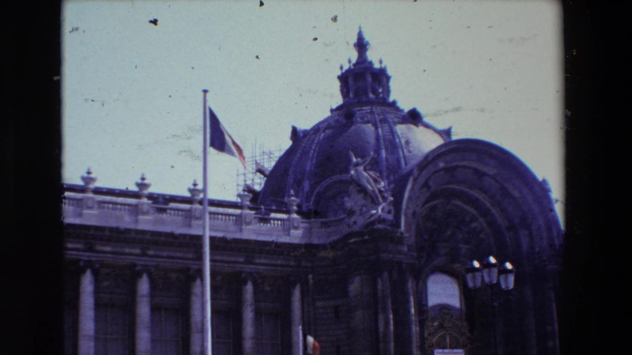 Closer view of the dome and half-mast flag above a classical facade.