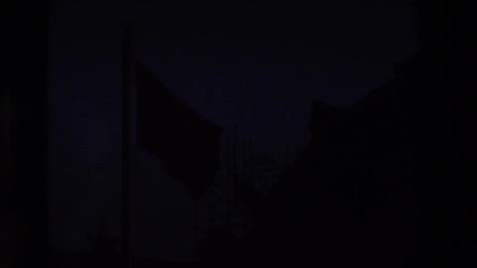 A darker frame shows the French flag and scaffolding mostly in silhouette beside shadowed architectural forms, consistent with the same Paris 8mm sequence.