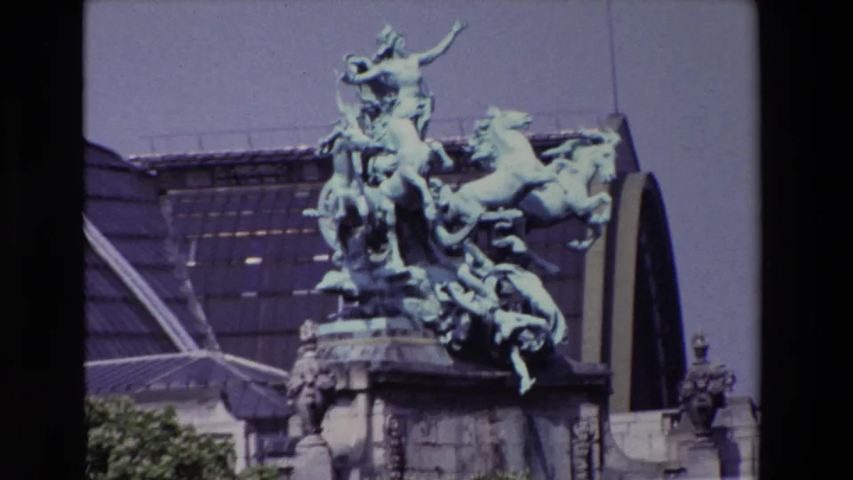 Final 1969 Paris frame centers the green-patinated equestrian sculpture above stone architecture, with glass roof panels and treetops at the lower edge.