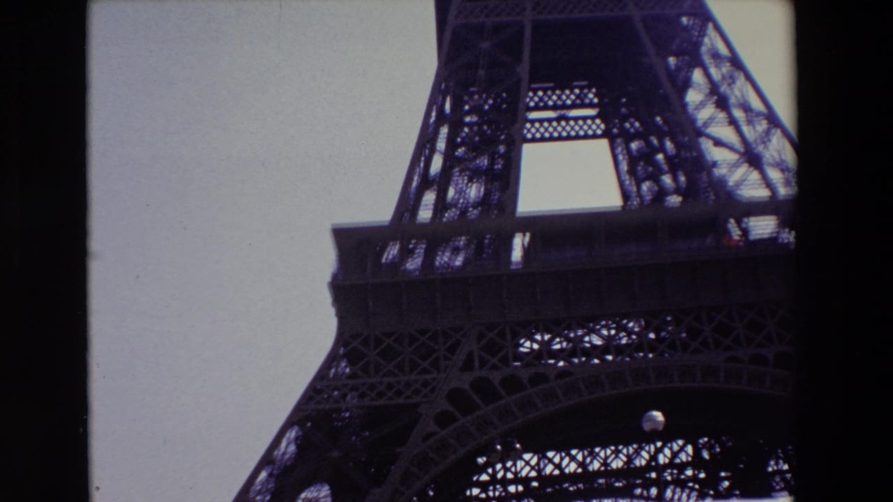 1969 Paris frame showing the Eiffel Tower from below, with the lower arch and dense iron lattice cropped by the 8mm film border.