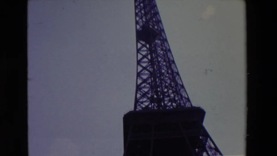 1969 Paris frame with the Eiffel Tower's lattice and platform dark against a pale sky, cropped by the contact-sheet layout and film borders.
