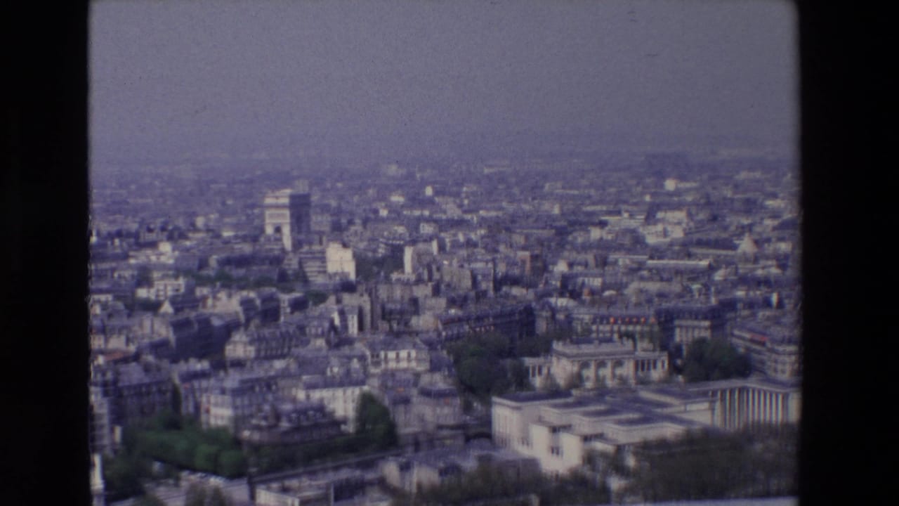 Wide city panorama with the Arc de Triomphe and surrounding Paris rooftops.