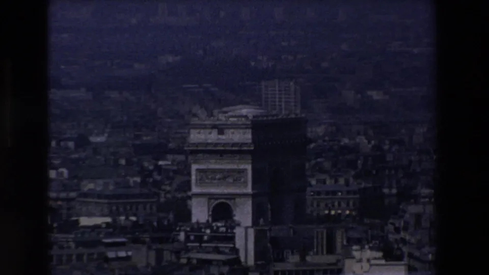 Blue-tinted 1969 Paris aerial view showing the Arc de Triomphe partially in shadow with the city receding behind it.
