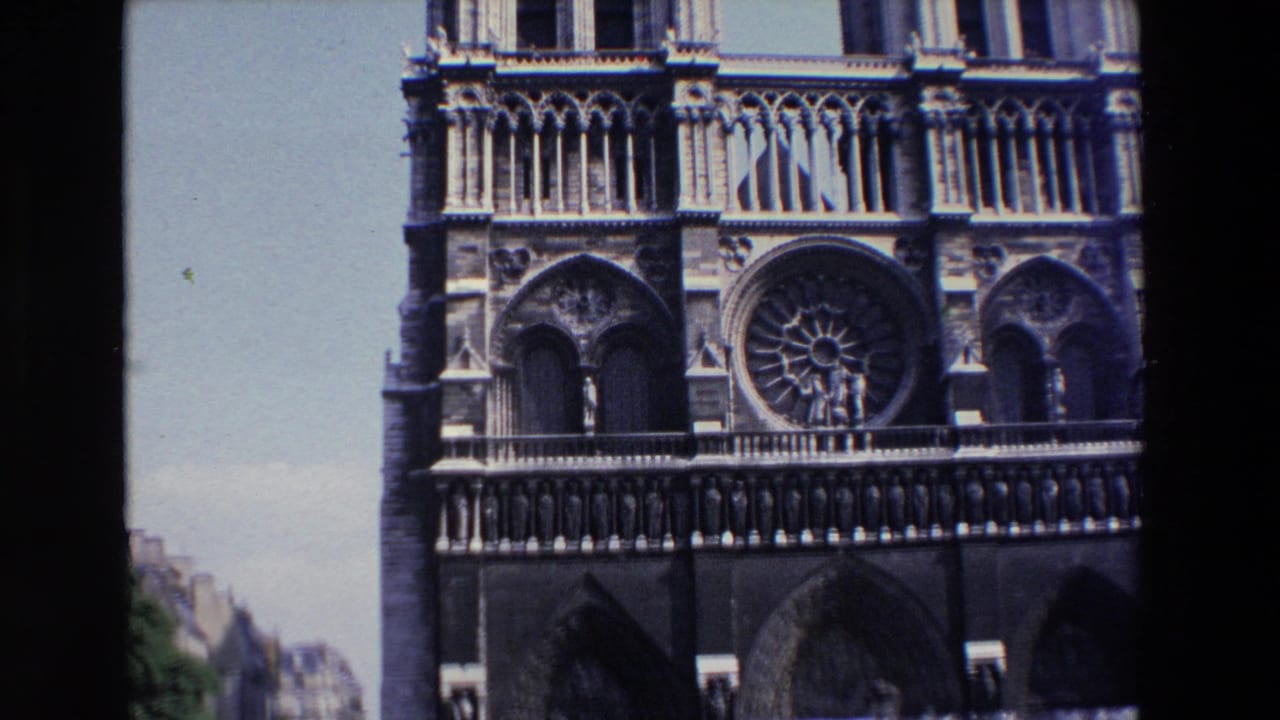 Closer view of Notre Dame's rose window, upper facade, and arched openings.